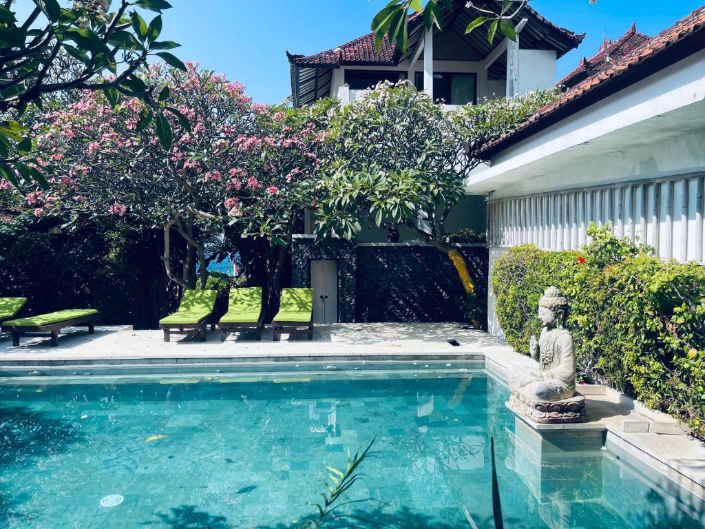 a swimming pool with a statue next to a house at Meditasi Bungalows & Villas in Amed