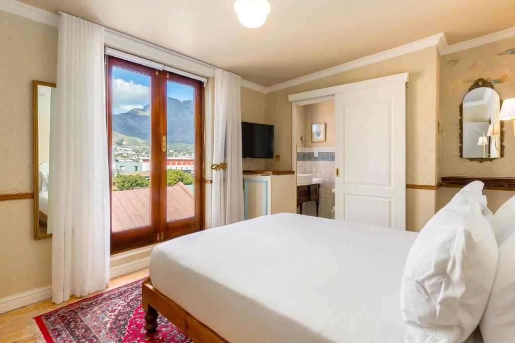 a bedroom with a bed and a large window at Royva Bo-Kaap in Cape Town