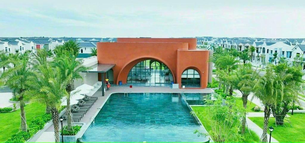 a house with a swimming pool in front of a building at VILLA NOVAWORLD PHAN THIET Beach in Phan Thiet