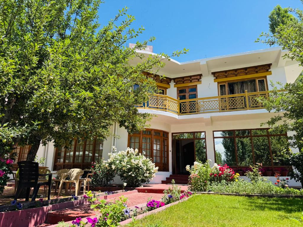 a house with a balcony and a garden at Hinjuma guest house in Leh