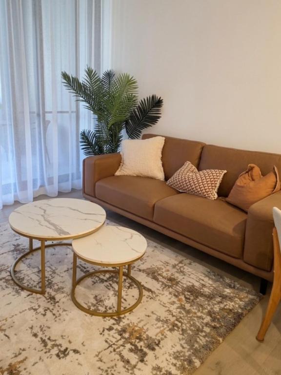a living room with a brown couch and two tables at Stylish 1BR Getaway and Option for 2nd Br in Campbell