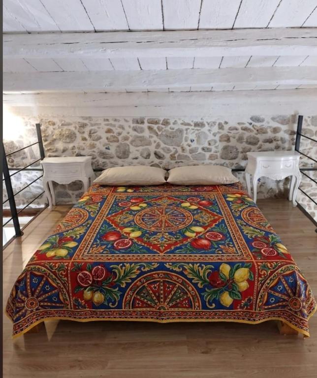 a bedroom with a bed with a colorful bedspread at La casetta in Trabia