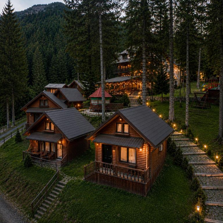 Eine Gruppe von Hütten im Wald bei Nacht in der Unterkunft Hanul Vânătoresc in Cumpăna