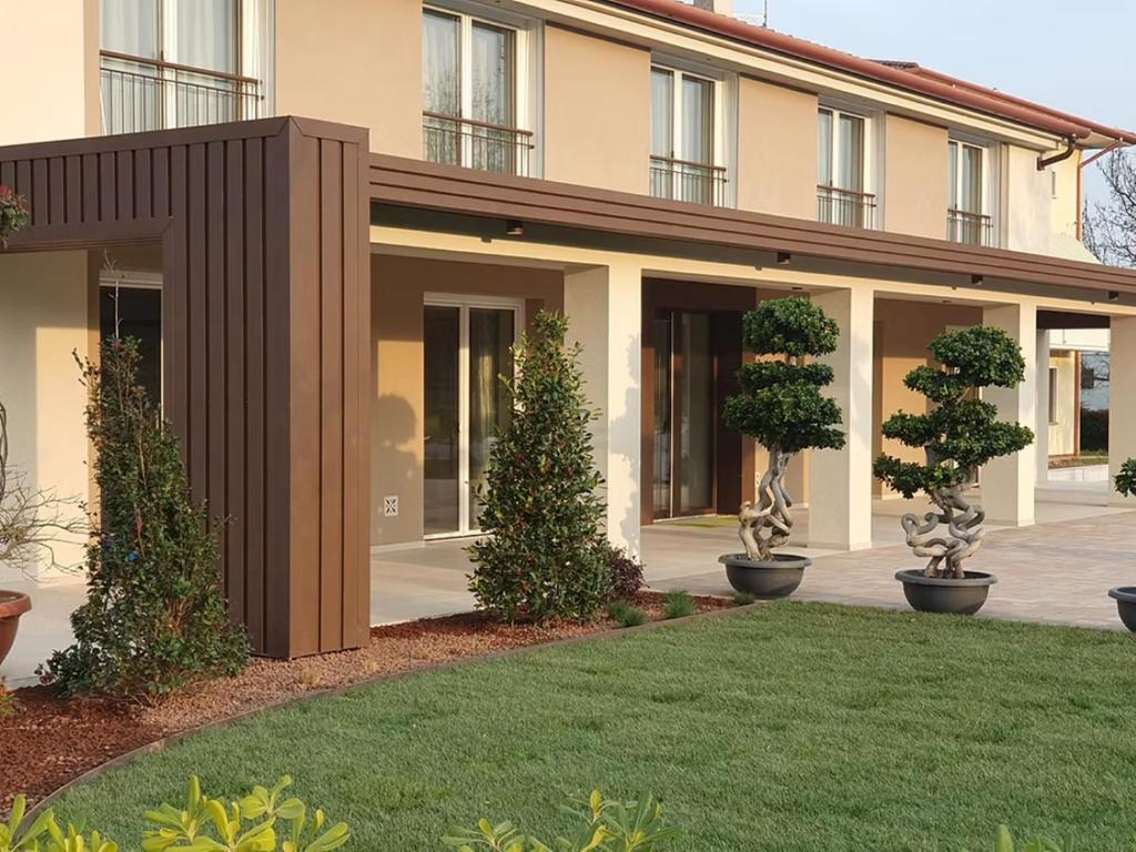 a building with trees in front of a yard at Agriturismo Camerin - CL Agri Lounge in Conegliano