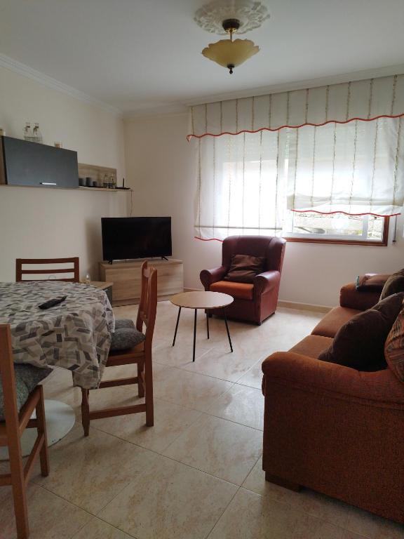 a living room with a couch and a table at VIVIENDA TURÍSTICA Bajo, 7 Escaleras in Laxe