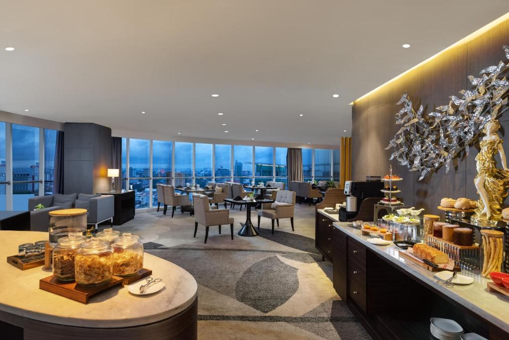 a restaurant with tables and chairs and windows at Meliá Makassar in Makassar