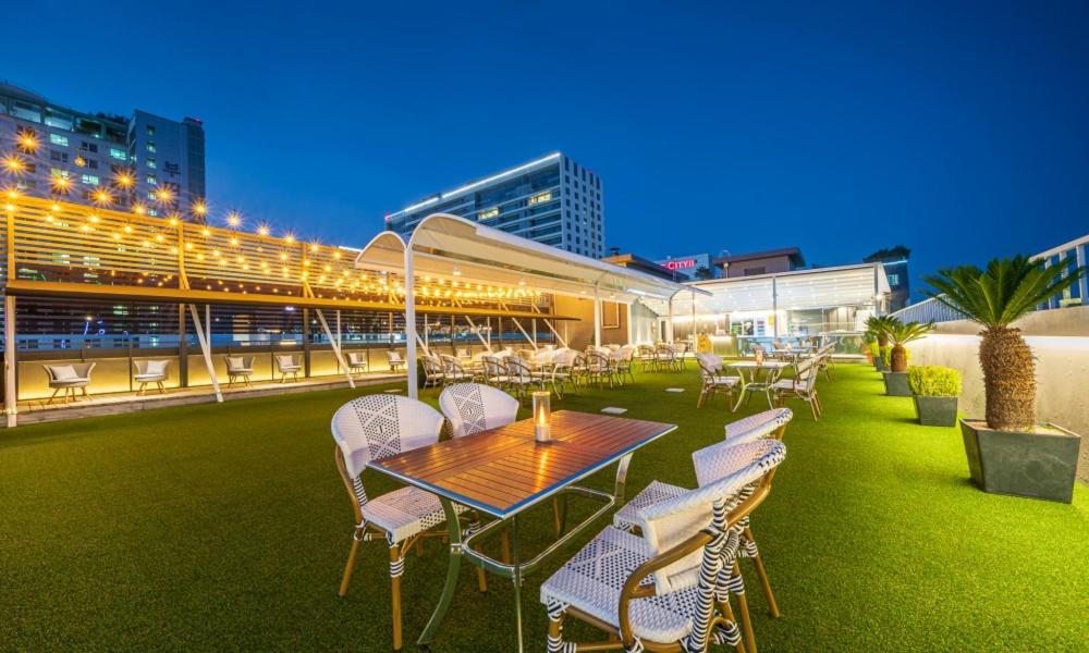 a patio with a table and chairs and a building at Dongdaegu Station Eastern Hotel in Daegu