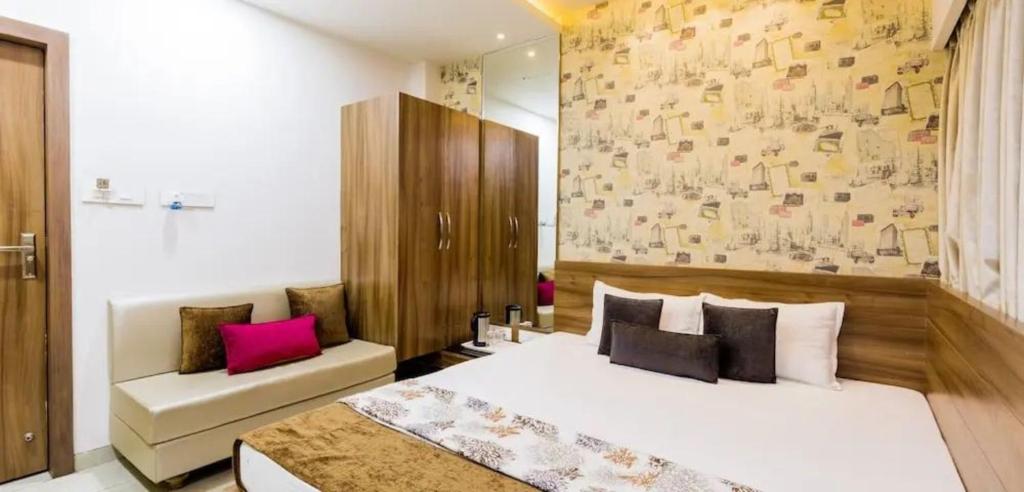 a bedroom with a large white bed and a couch at Hotel Rockland Kota in Kota
