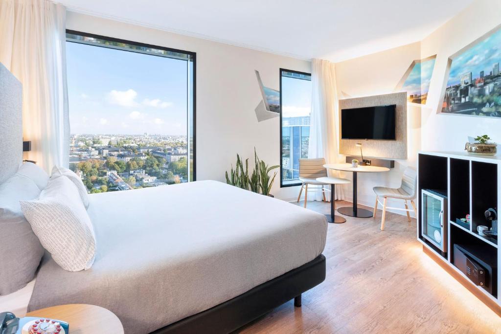 a bedroom with a bed and a large window at INNSiDE by Meliá Amsterdam in Amsterdam