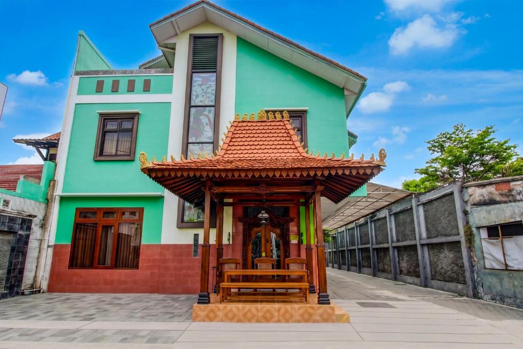 a building with a bench in front of it at Hotel O near Alun-Alun Kidul formerly Ndalem Mantrijeron Hotel in Yogyakarta
