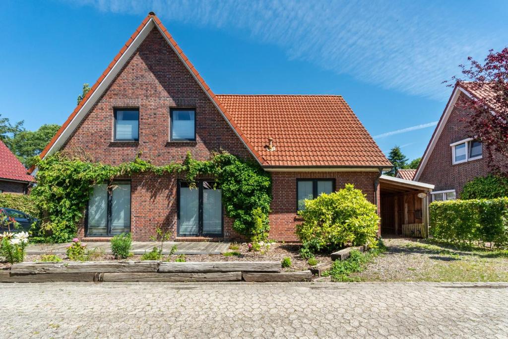 a brick house with an orange roof at Ferienwohnung Glück In Dornum in Dornum