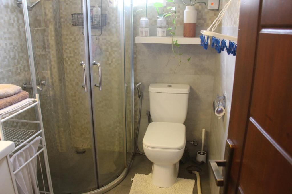 a small bathroom with a toilet and a shower at Kavis Home in Ekalakurunduwatta