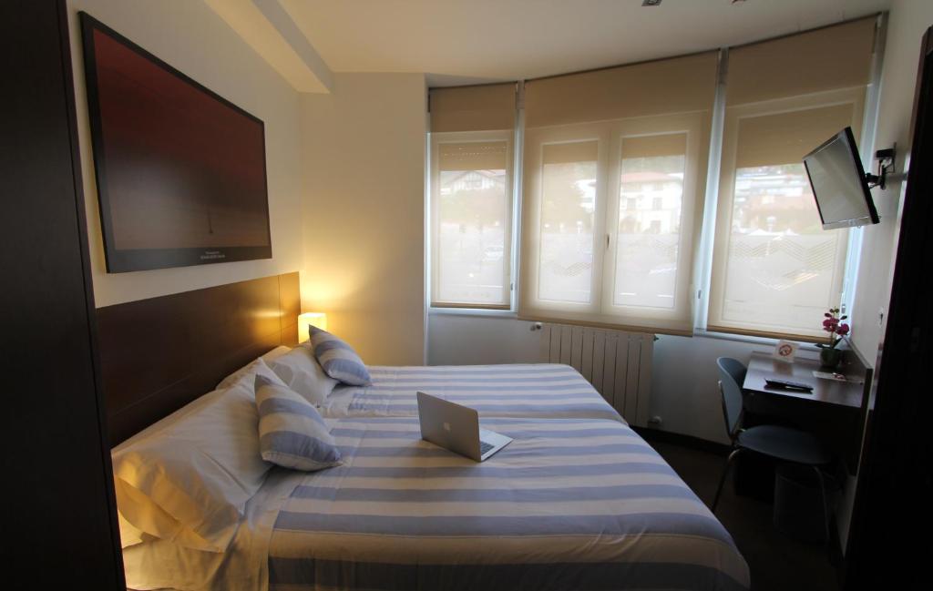 a hotel room with a bed with a laptop on it at Pensión Grosen in San Sebastián