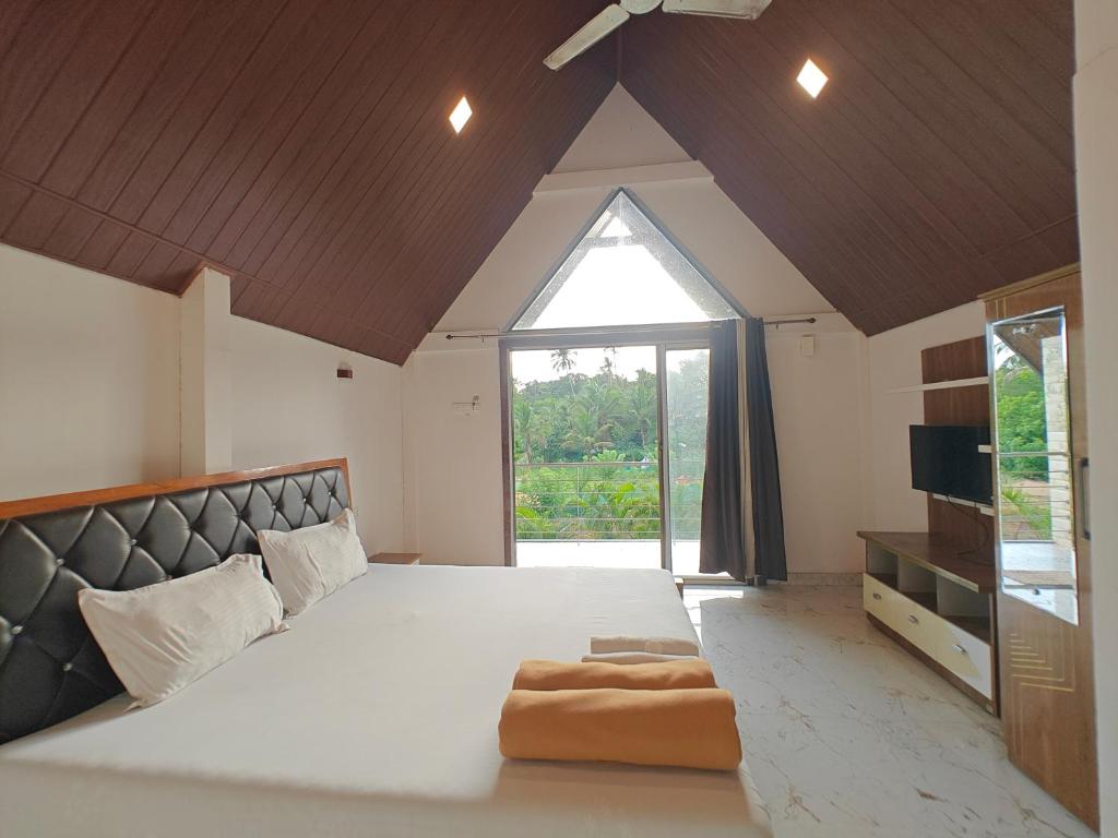 a large bedroom with a large bed and a window at Mermaid Avisa in Arambol