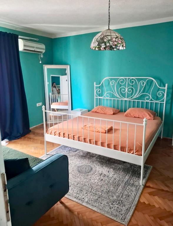 a blue bedroom with a bed and a mirror at Art House Old Town in Podgorica