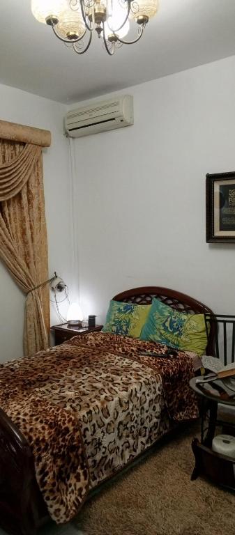 a bedroom with a bed and a chandelier at Dar salam in Tunis