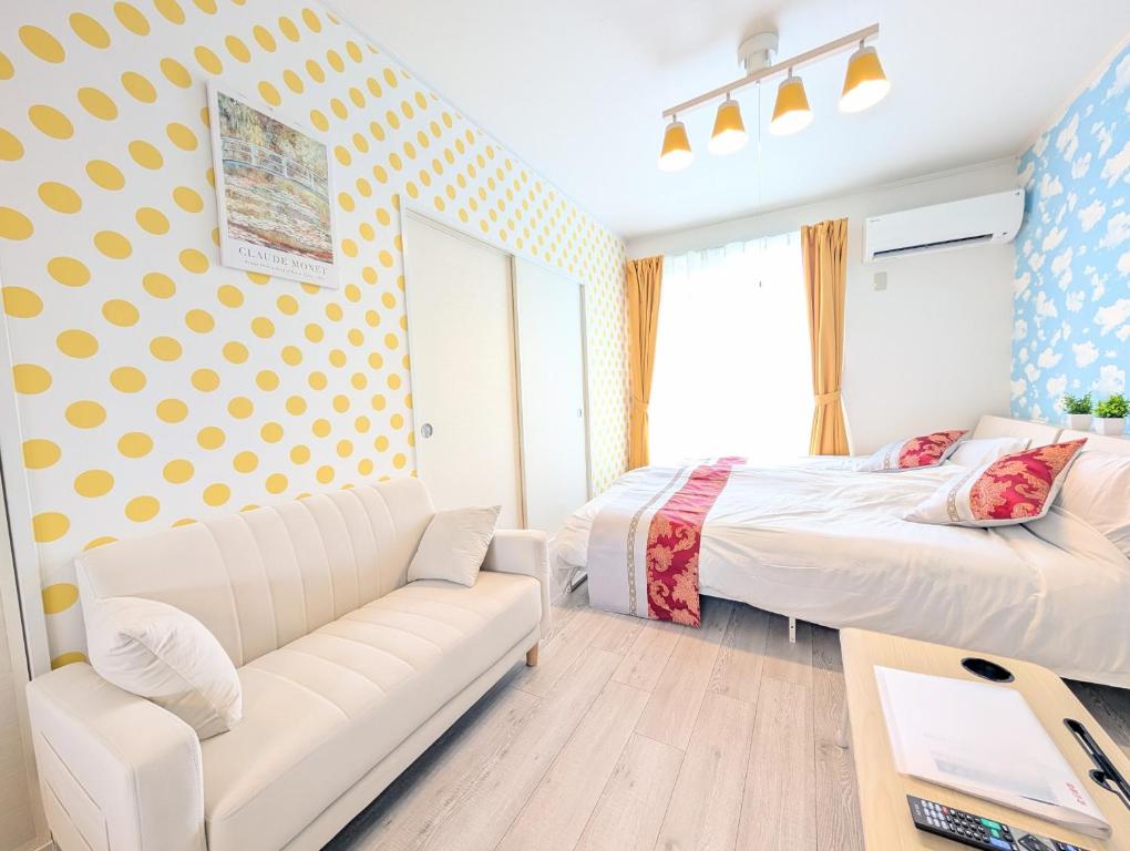 a living room with a bed and a couch and a bed and a couch at Maison New River B-203 in Chiharachō