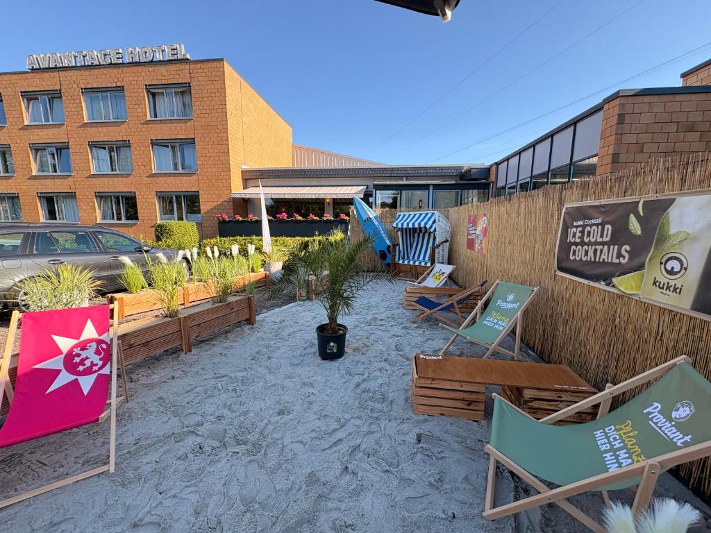 a patio with chairs and tables and a building at Nordic Avantage Hotel in Kiel