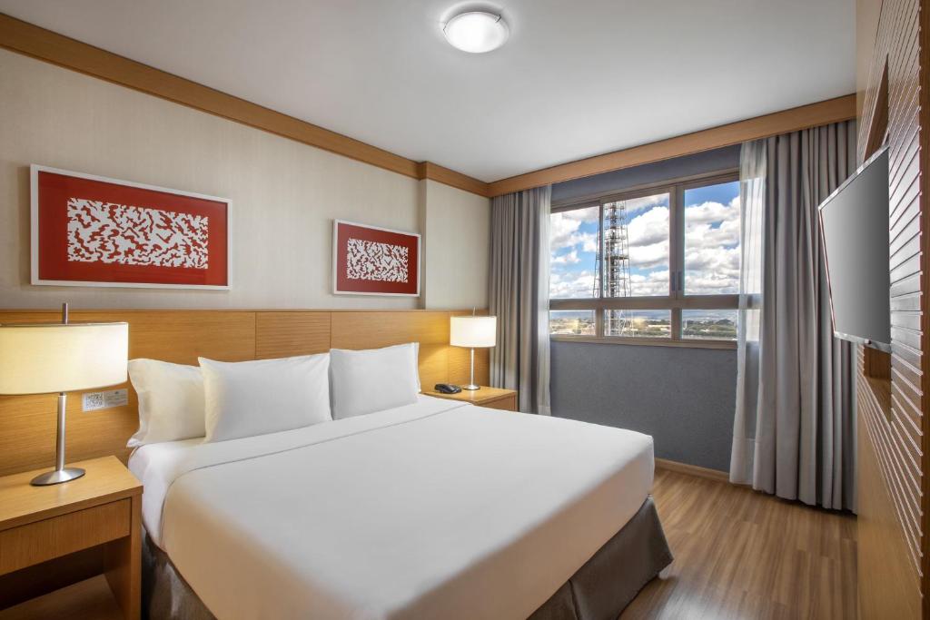 a hotel room with a large bed and a window at Hotel Brasil 21 Convention, Affiliated by Meliá in Brasília