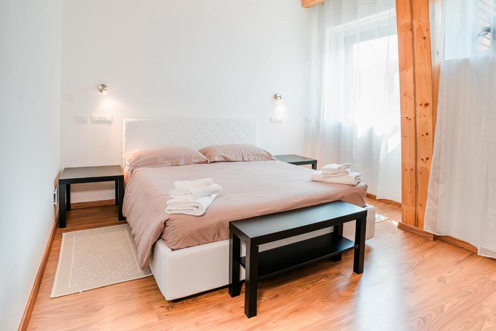 a bedroom with a large bed with two tables at Affitta camere LUNAR in Borgo