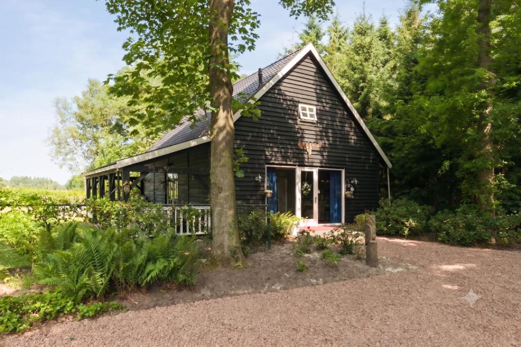 a wooden house with a tree in front of it at The Mansion in Wijnjewoude