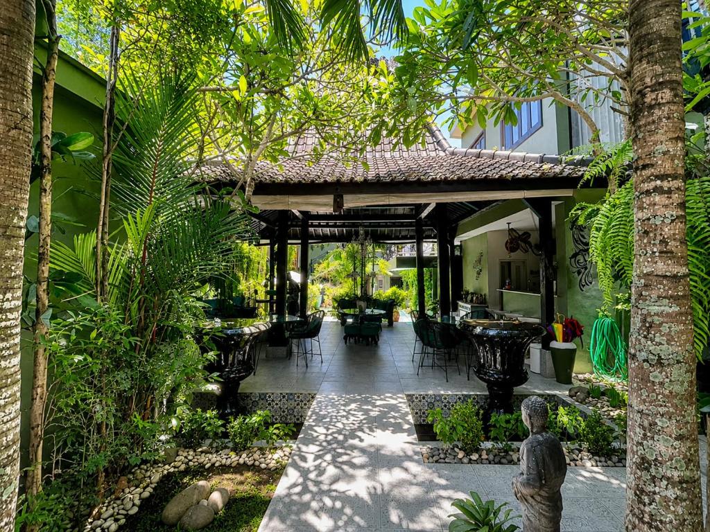 a courtyard of a house with chairs and trees at The Lodge Canggu in Tumbak Bayuh