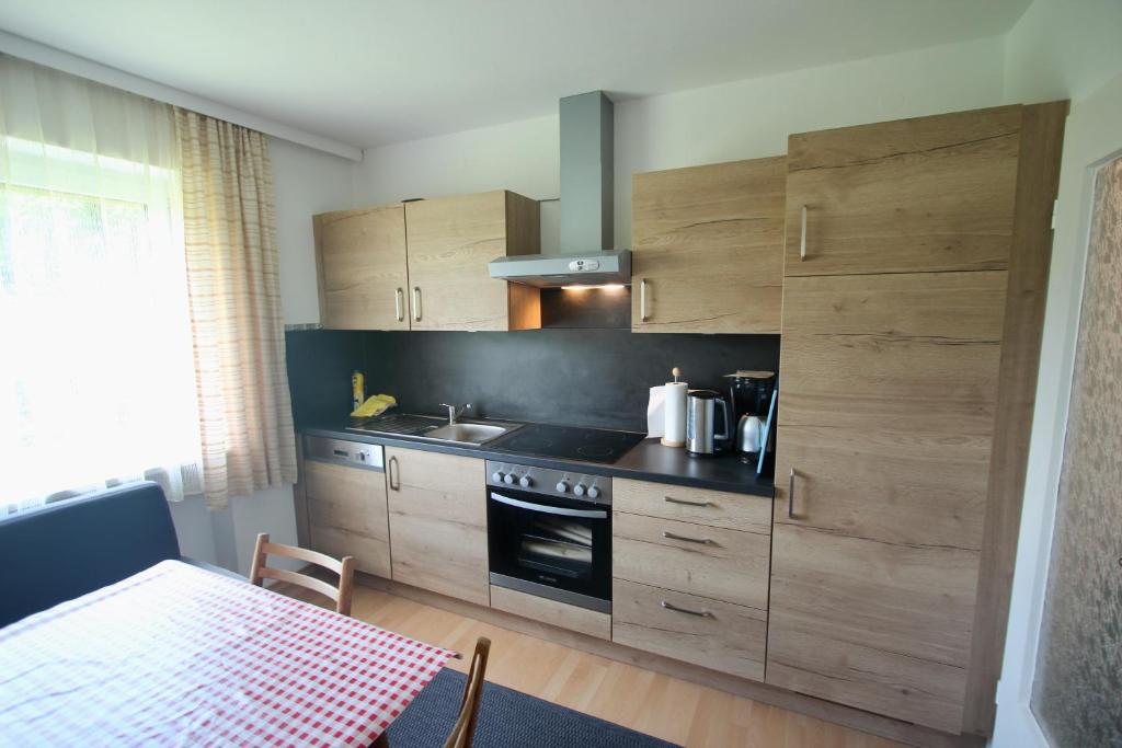 a kitchen with wooden cabinets and a stove top oven at Haus die Gerti - Ilz in Waldkirchen