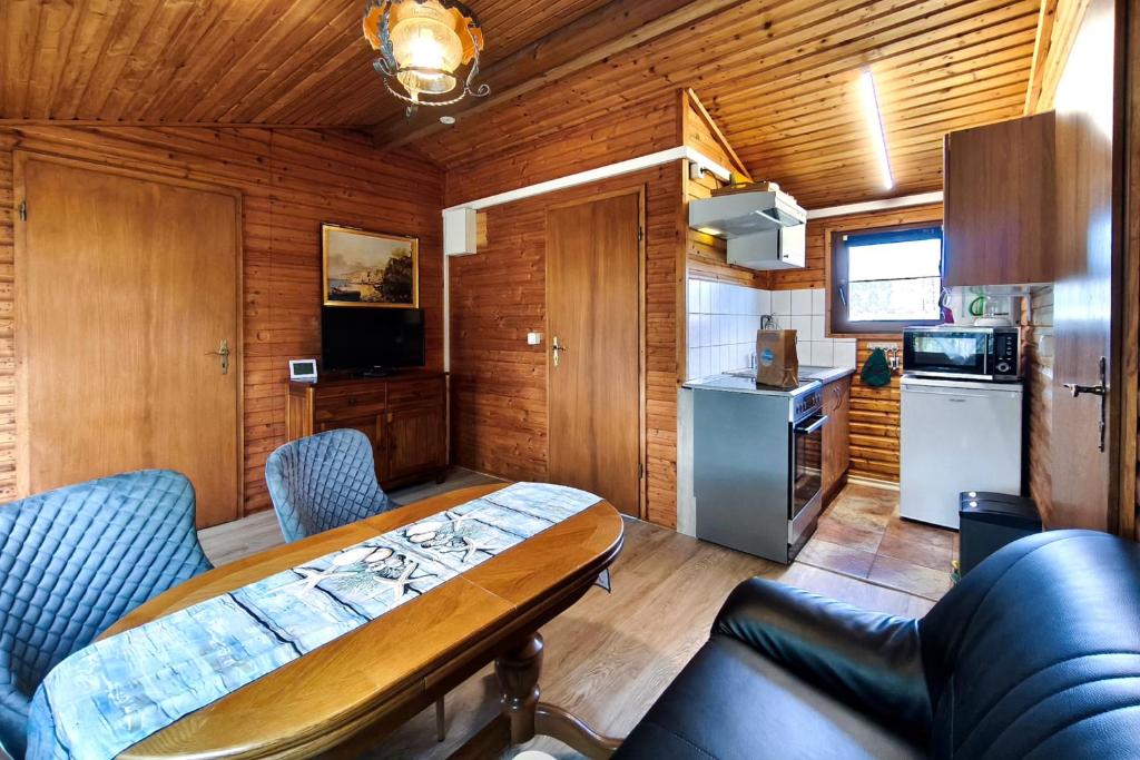 a small room with a table and a kitchen at Ferienbungalow Seeluft in Loddin
