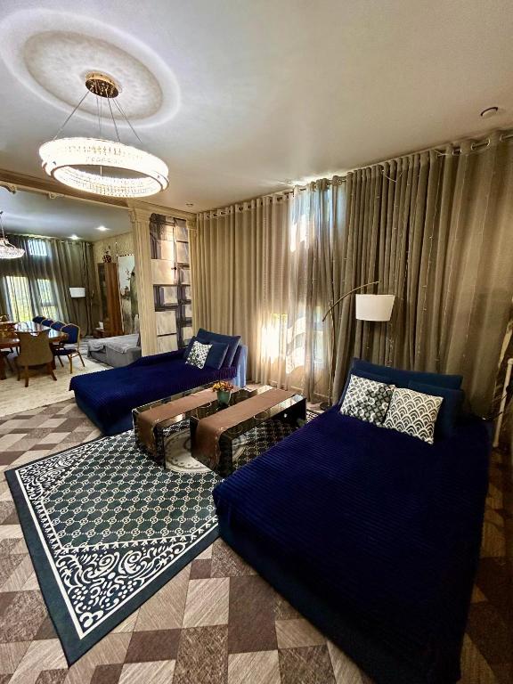 a living room with blue beds and a couch at Дача в городе in Bishkek