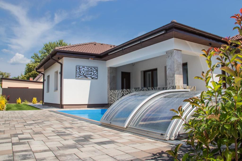 a home with a swimming pool and a house at Luca Villa in Balatonlelle