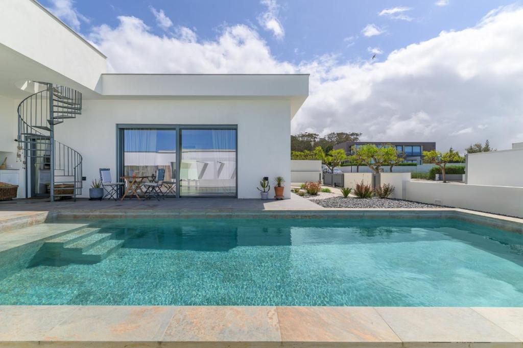 a swimming pool in the backyard of a house at Vila Adelino in Sines