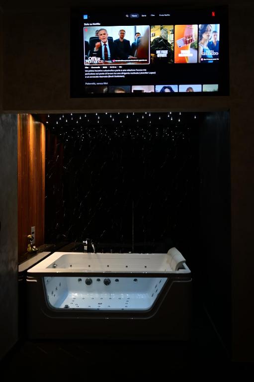 a bathroom with a tv and a white sink at ASTRUM b&b in Cosenza
