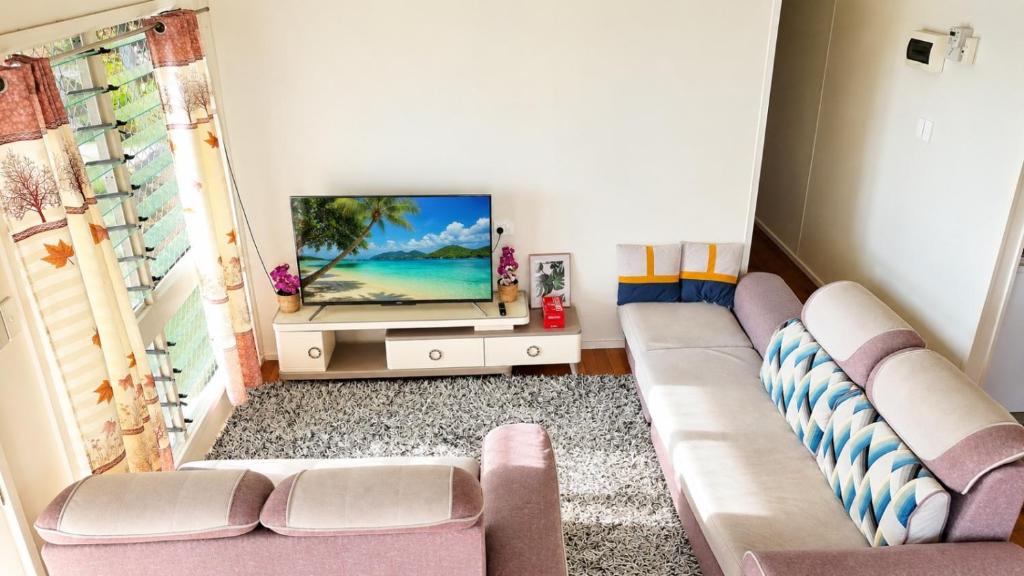 a living room with a couch and a flat screen tv at Auki Ocean View in Auki