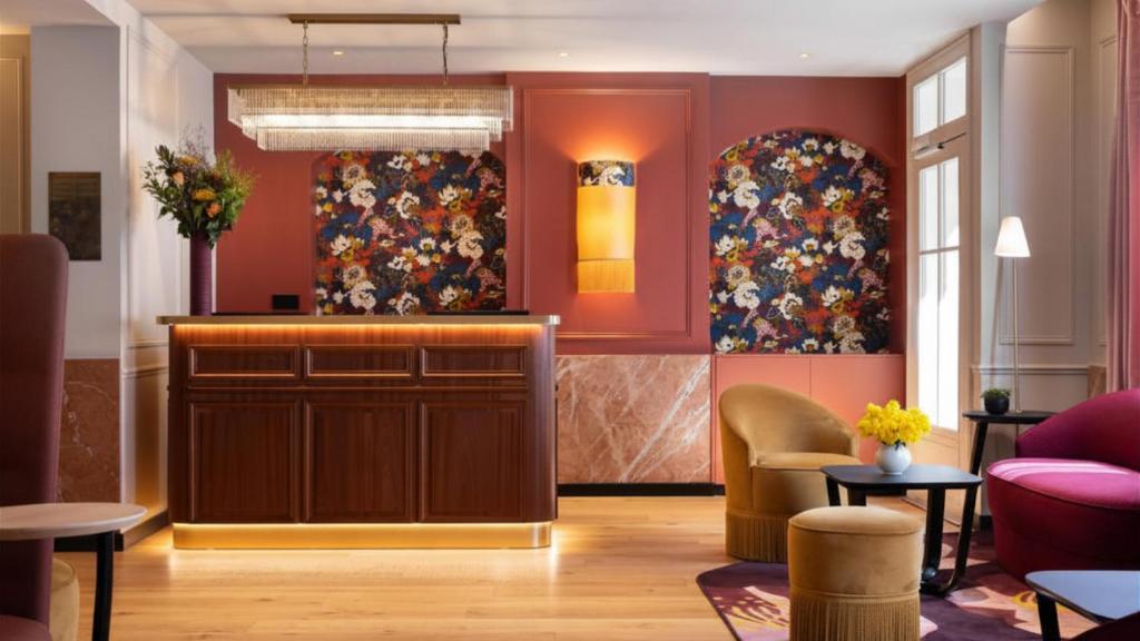 a lobby with red walls and floral wallpaper at Hôtel Mayflower Opera in Paris