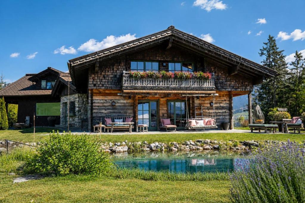 a log cabin with a pond in front of it at Jagdhaus Umlberg in Umlberg