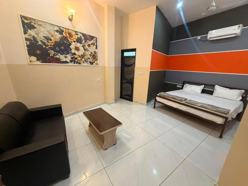a bedroom with a bed and a couch and a painting at The Urban Lodge in Goriān