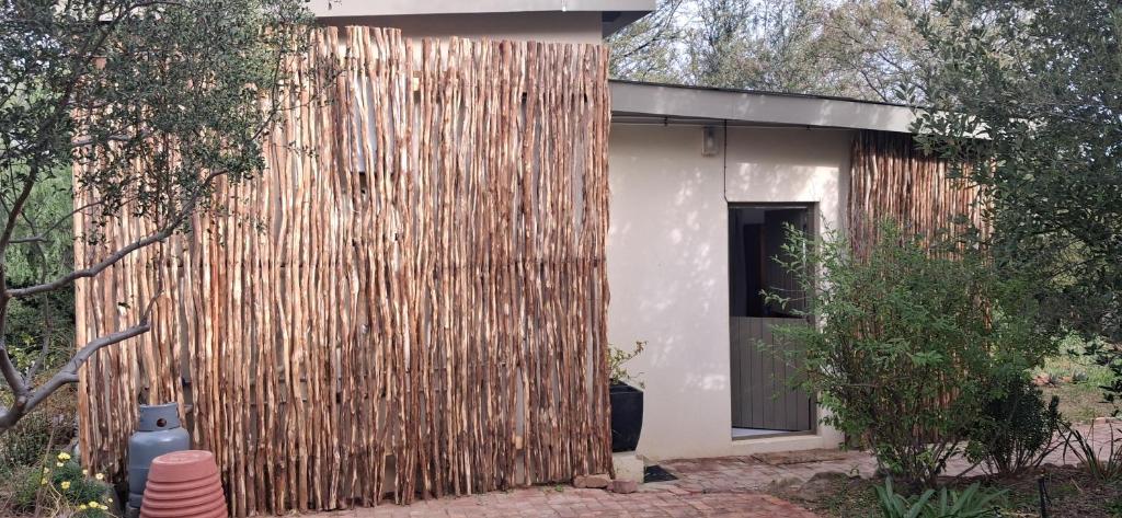 a wooden fence next to a house with a door at Hope's Harvest Nook in Montagu