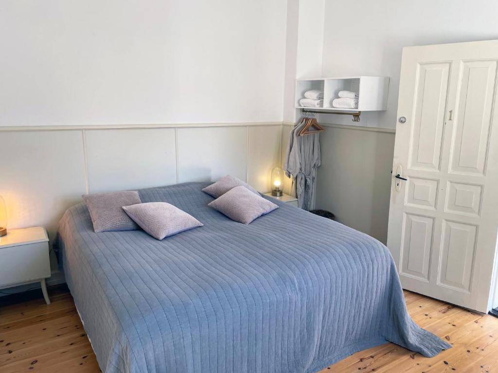 a bedroom with a blue bed with two pillows at Lundsgaard Gods ferielejlighed in Kerteminde