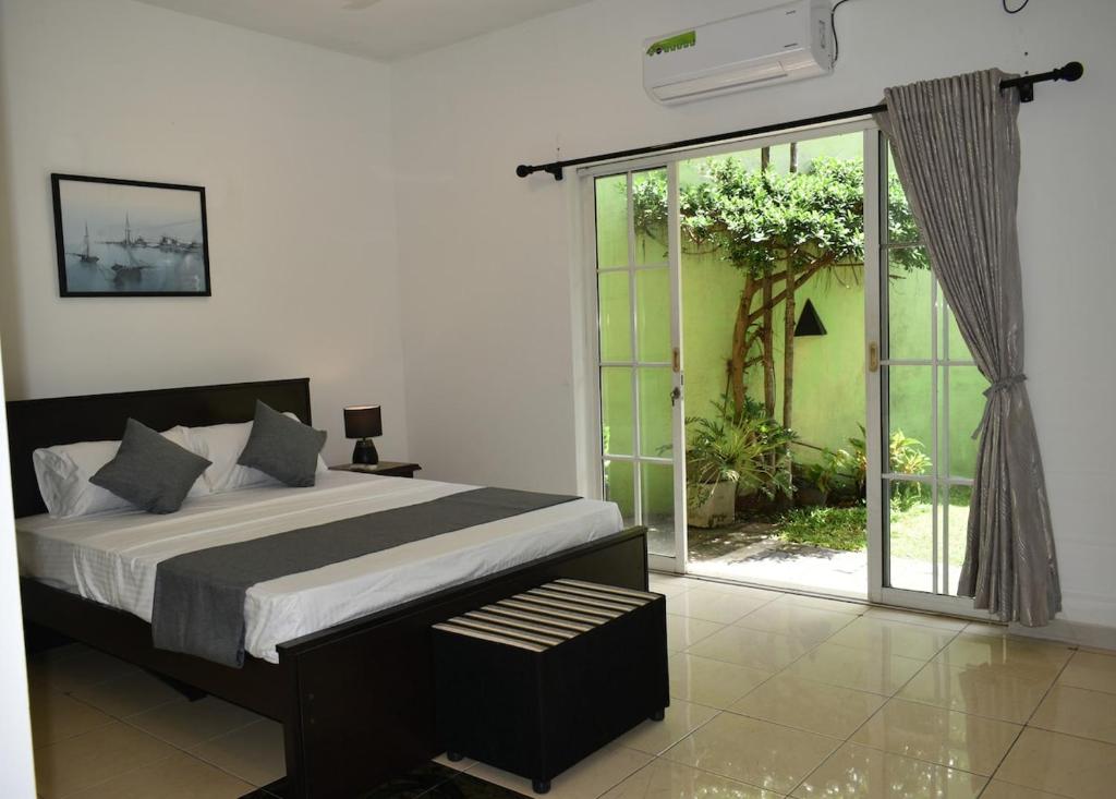 a bedroom with a bed and a large window at Casa Solare in Wellawatta