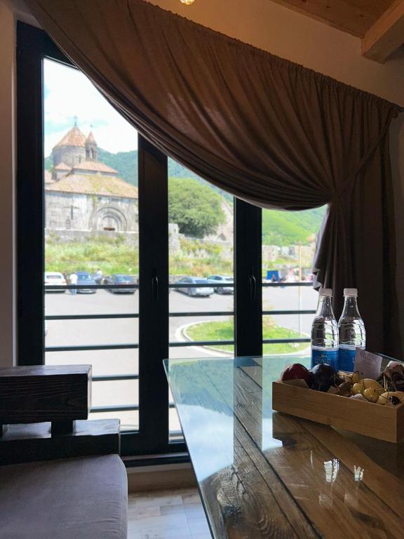 a glass table with a bowl of fruit in front of a window at RestList in Haghpat