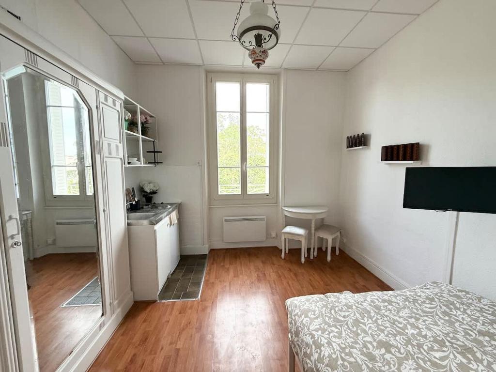 a bedroom with a bed and a sink and a table at Studio plein centre et parking in Châtel-Guyon