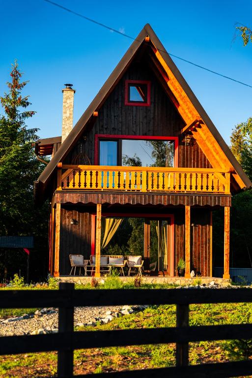 a log cabin with a fence in front of it at Casa Sunetul Padurii din Belis Apuseni in Călăţele
