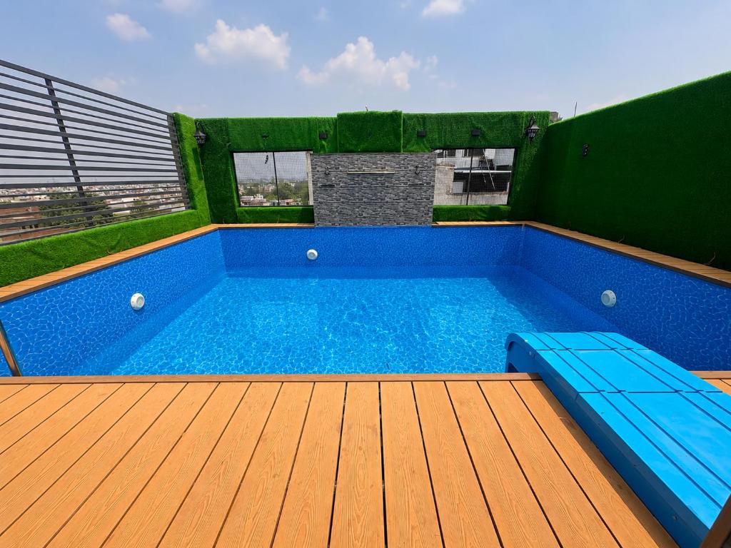 a swimming pool on a deck with a wooden floor at Hotel Next View Amritsar # Pool # Parking # Family Hotel # Best choice for Tourists in Amritsar