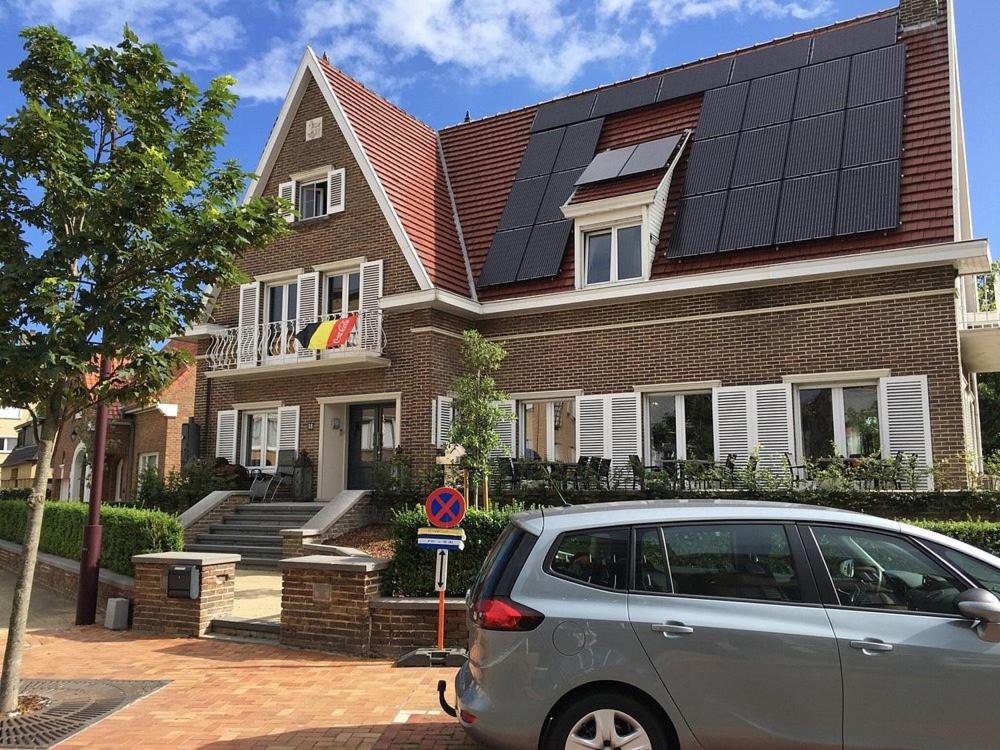 a house with solar panels on the roof at Villa Amylia & gratis parking in Wenduine