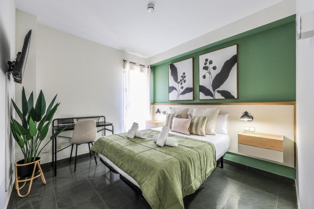 a bedroom with a bed with a green wall at UP Hotel Velilla in Velilla de San Antonio