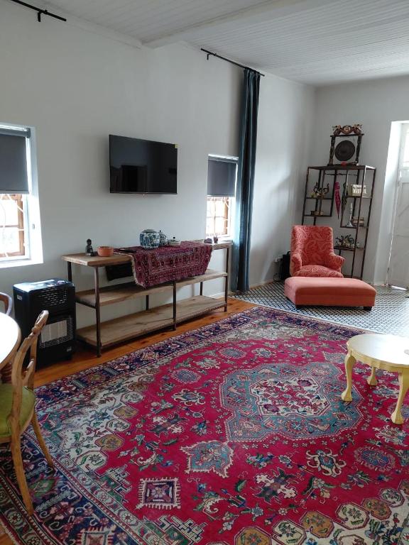 a living room with a red couch and a red rug at The Galleons in Barrydale