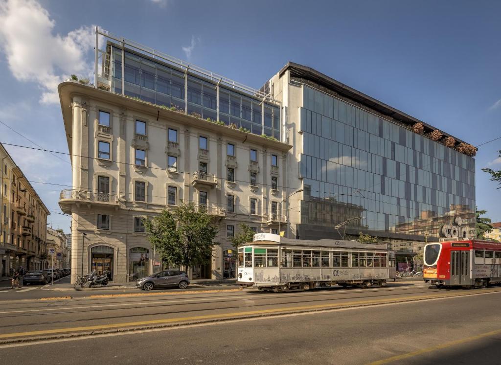 a city street with a building and a tram at Palazzo Vittoria Hotel Milano in Milan
