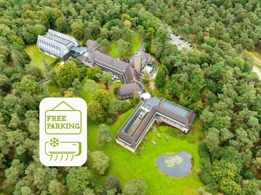 an aerial view of a building in the middle of a forest at Hotel Woudschoten in Zeist
