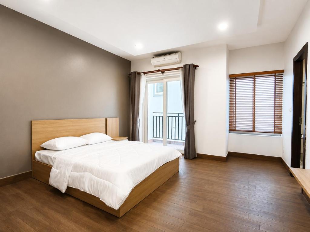 a bedroom with a bed and a large window at Sopor Resident in Phnom Penh