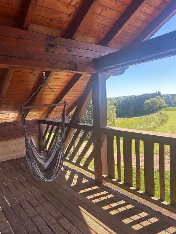 a hammock hanging on a porch of a cabin at Ferienwohnung Heuboden in Reut